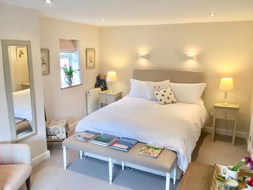 1 dormitorio con 1 cama y 1 mesa con libros en Brook Farm Cottage, en Brackley