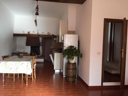 uma cozinha com uma mesa e um frigorífico em Poggio Moretto em Manciano