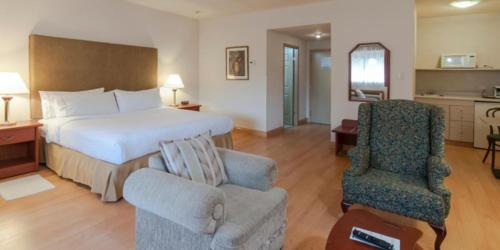 チワワにあるHoliday Inn Express Chihuahua, an IHG Hotelのベッドと椅子付きのホテルルーム