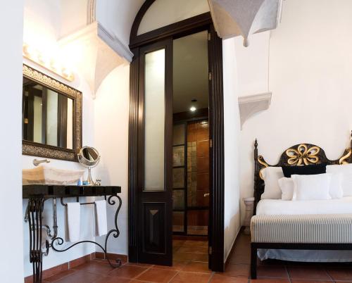 a bedroom with a bed and a mirror and a sink at Hotel Herencia By Hosting House in Morelia