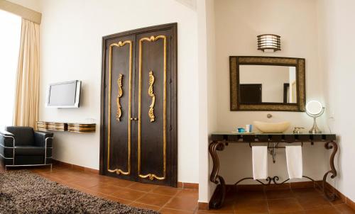 a bathroom with a black door and a mirror at Hotel Herencia By Hosting House in Morelia