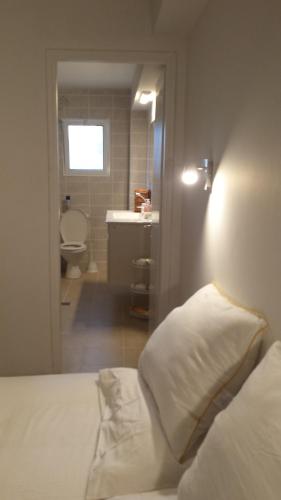 a bedroom with a bed and a bathroom with a sink at Alona in Kefar Weradim