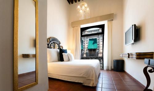 a bedroom with a bed and a mirror at Hotel Herencia By Hosting House in Morelia