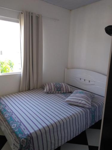 フロリアノポリスにあるPousada Pingo de Ouroの小さなベッドルーム(窓付きのベッド付)
