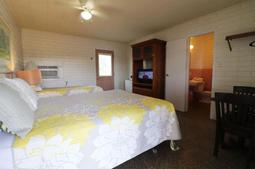 a bedroom with a large bed and a television at Big River Marina & Lodge in Astor