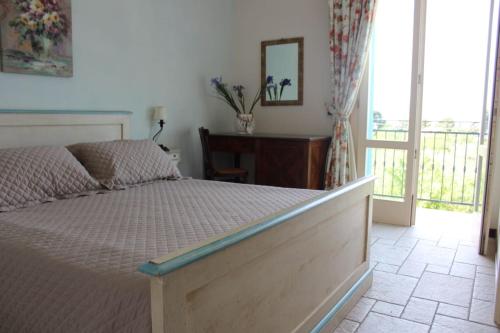 a bedroom with a bed and a door to a balcony at Catarin Comfort Rooms in Castelluzzo