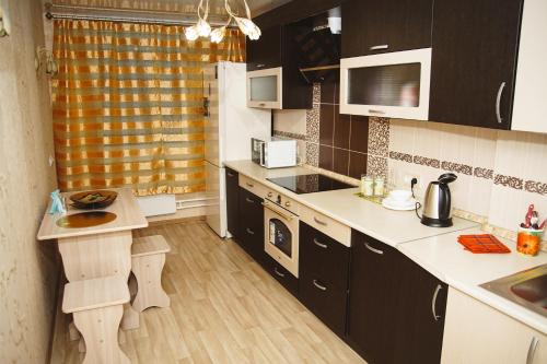 ヴェルフナヤ・ピシュマにあるАпартаменты Натальиの小さなキッチン(黒いキャビネット、白いカウンター付)