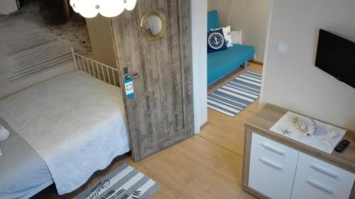 um pequeno quarto com uma cama e uma televisão em SEA Apartment em Hel