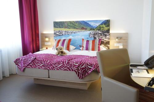 a dog sitting on a bed in a bedroom at Hotel Edel Weiss in Bremen