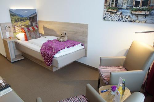 a room with a bed with a stuffed animal on it at Hotel Edel Weiss in Bremen