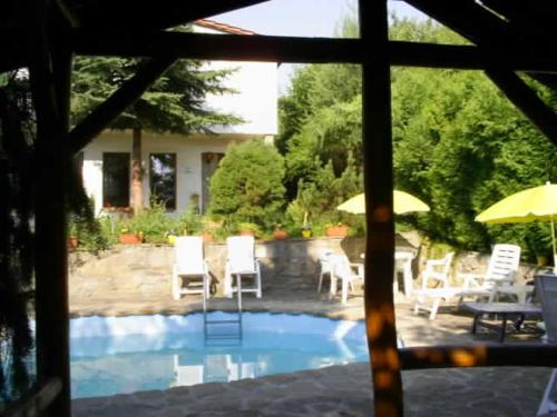 a view of a swimming pool with white chairs and umbrellas at Farma Zdrowia in Znamirowice