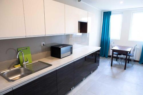 沃姆扎的住宿－M&A GUEST ROOMS，厨房配有白色橱柜、水槽和桌子