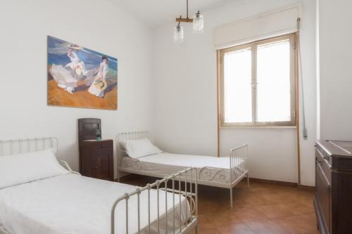 a bedroom with two beds and a window at Casetta Canale delle Donne in Marina di Mancaversa