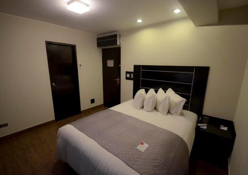 a hotel room with a large bed with white pillows at qp Hotels Arequipa in Arequipa