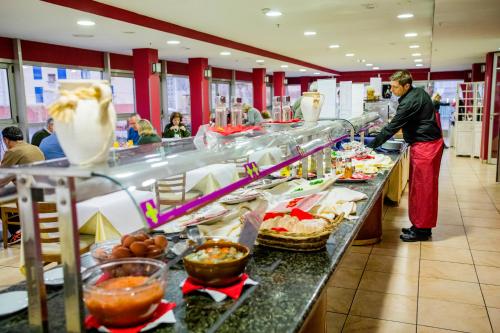 a man standing at a buffet line in a restaurant at Hotel Biarritz in Gandía