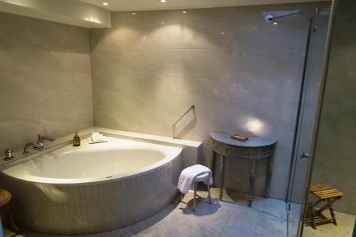 a bathroom with a large tub and a shower at Hotel de la Gaichel in Eischen