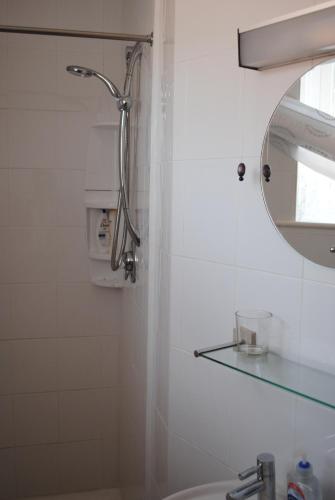 y baño con ducha, espejo y lavamanos. en The Flintstones Guesthouse en Weymouth