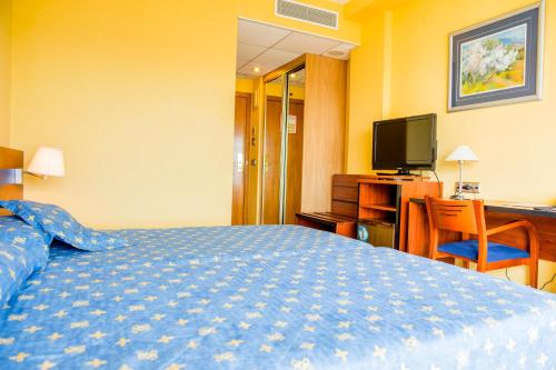 a hotel room with a bed and a television at Hotel Biarritz in Gandía