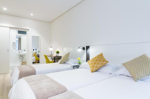 um quarto com 2 camas e uma sala de estar em Pensión Buenpas em San Sebastián
