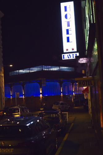 a hotel sign with cars parked in a parking lot at night at The Old Hotel Ravel Centre in Clermont-Ferrand