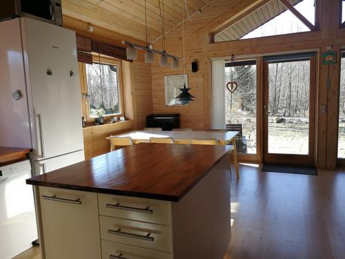 a kitchen with a refrigerator and a table with chairs at Pusterummet, Klåveröd in Klåveröd