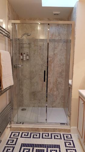a shower with a glass door in a bathroom at The Old Cottage in Arduaine