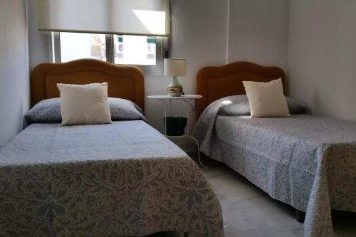 タリファにあるApartamento Abrilのベッドルーム1室(ベッド2台、窓付)