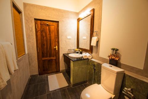 a bathroom with a toilet and a sink and a mirror at Seasons Villa - Nuwara Eliya in Nuwara Eliya