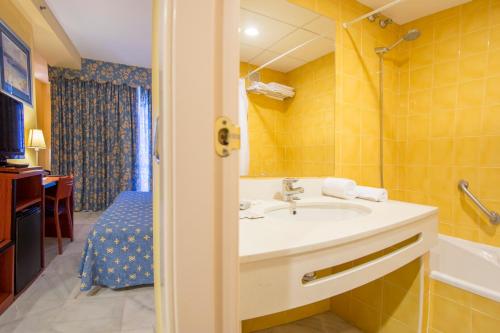 a bathroom with a sink and a bath tub at Hotel Biarritz in Gandía