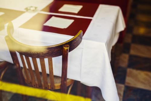 a table with a white table cloth on a wooden chair at The Old Hotel Ravel Centre in Clermont-Ferrand