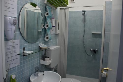 y baño con ducha, aseo y lavamanos. en B&B La casa di Luigi, en Giardini Naxos