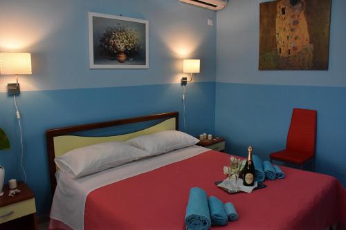 a bedroom with a bed with a red blanket and a red chair at B&B La casa di Luigi in Giardini Naxos