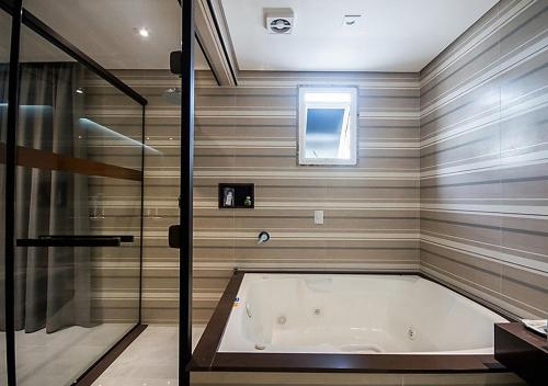 a bathroom with a bath tub and a shower at Caribe Motel (Adult Only) in Sao Paulo