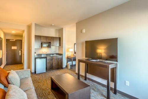 a living room with a couch and a kitchen at Wingate by Wyndham Loveland Johnstown in Loveland