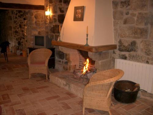 a living room with two chairs and a fireplace at El Racó de les Grases in Horta de San Joan