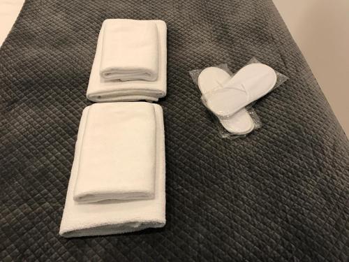 a pair of towels and a heart on a bed at DbD Apartament - Gray Turkus in Szczecin