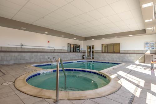 a pool in a building with a swimming pool at Wingate by Wyndham Loveland Johnstown in Loveland