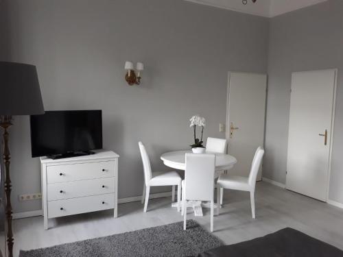 a white dining room with a white table and chairs at Seeblick Apartment/Zimmer in Gmunden