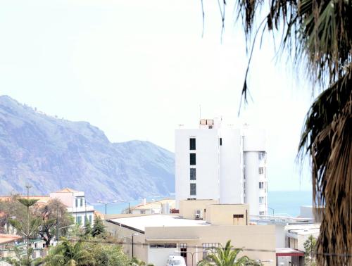 a white building with the ocean in the background at Mericia's Gorgeous View in Funchal
