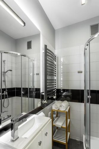 a bathroom with a sink and a shower at Apartamenty Centrum Częstochowa Stara Kamienica in Częstochowa