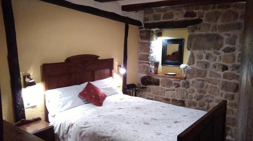 a bedroom with a large bed in a stone wall at El Racó de les Grases in Horta de San Joan
