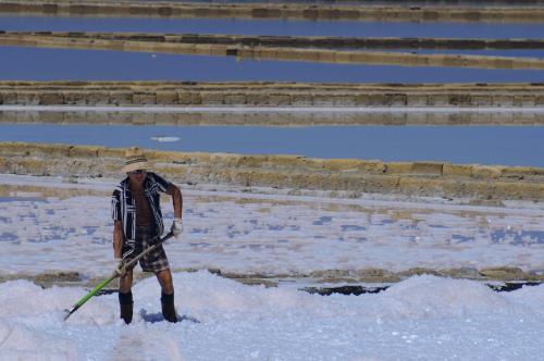 a man is standing in the water with a paddle at Anita & Garibaldi in Marsala