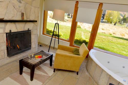 a living room with a tub and a fireplace at Galileo Boutique Hotel in San Carlos de Bariloche