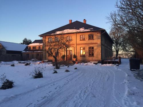 a large brick house with snow on the ground at Gutshaus Lexow in Lexow