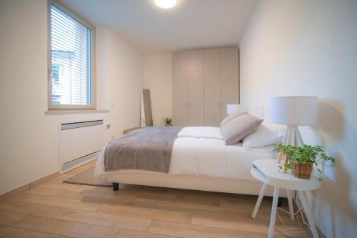 a bedroom with a bed and a table and a window at Comonfive Apartments in Como