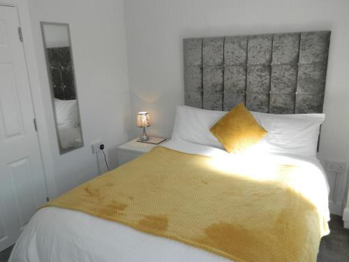 a bedroom with a large bed with a yellow blanket at Ocean Bay in Blackpool