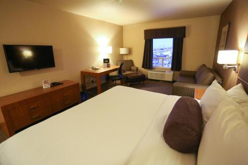 a hotel room with a large bed and a television at Days Inn by Wyndham Calgary Airport in Calgary