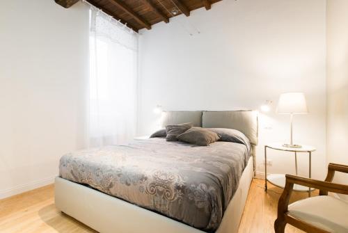 a bed in a white room with a large window at Casa Albalonga in Castel Gandolfo