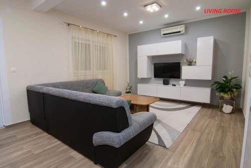 a living room with a couch and a television at Apartments Lokva in Lokva Rogoznica