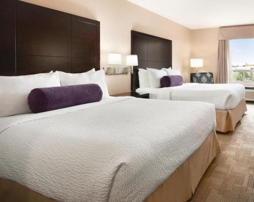 a hotel room with two beds and a window at Days Inn by Wyndham Calgary Airport in Calgary